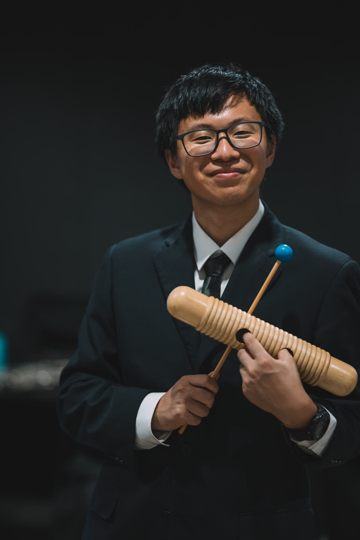 NTUSO percussionist holding a guiro and mallet